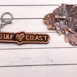 Siesta Key Gulf Coast Love Keychain souvenir with shells next to it