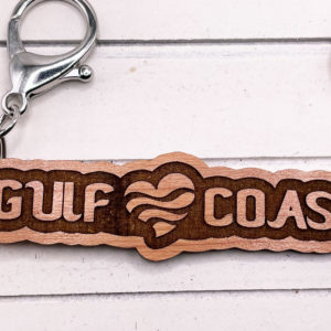 Siesta Key Gulf Coast Love Keychain souvenir with shells next to it in a close up view.